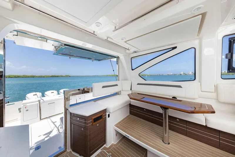 Slide: The Image of Manufacturer Provided Image: 2025 Pursuit OS 445 Offshore yacht interior with elegant seating and ocean view. - 10