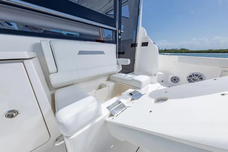 Slide: The Image of Manufacturer Provided Image: 2025 Pursuit OS 445 Offshore boat interior with white seating and ocean view. - 18