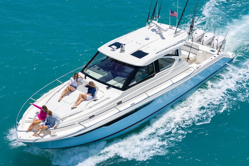Slide: The Image of Manufacturer Provided Image: 2025 Pursuit OS 445 Offshore yacht cruising with passengers on turquoise water. - 3