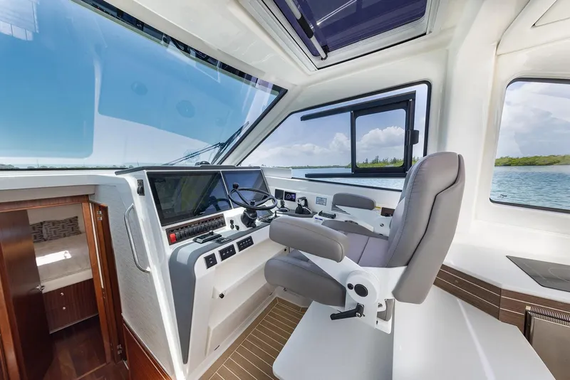 Slide: The Image of Manufacturer Provided Image: 2025 Pursuit OS 445 Offshore helm with modern controls and panoramic windows. - 9
