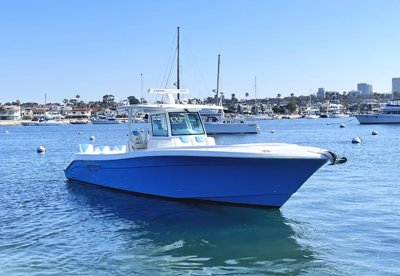 Slide: The Image of 2018 HCB 39 Speciale boat on calm water, with marina and cityscape in background. - 1