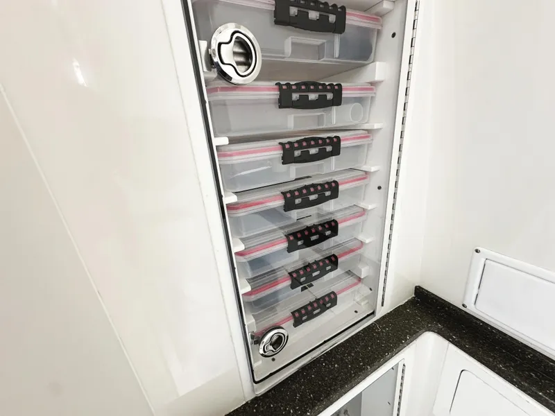 Slide: The Image of Storage compartments in a 2018 HCB 39 Speciale boat, featuring organized tackle boxes. - 37
