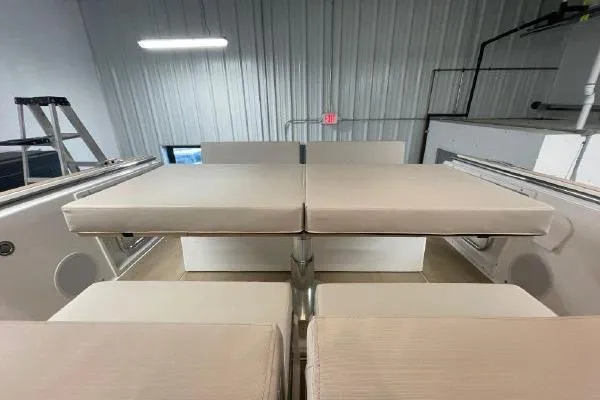 Slide: The Image of 2023 Fjord 38 Xpress boat interior with beige seating and table in a showroom. - 35