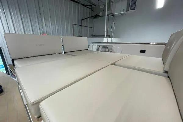 Slide: The Image of 2023 Fjord 38 Xpress boat interior with beige seating in a modern setting. - 36