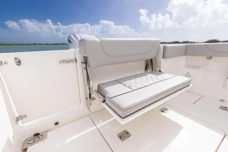 Slide: The Image of Manufacturer Provided Image: 2025 Pursuit S 248 Sport boat with foldable seating, white upholstery, and ocean backdrop. - 15