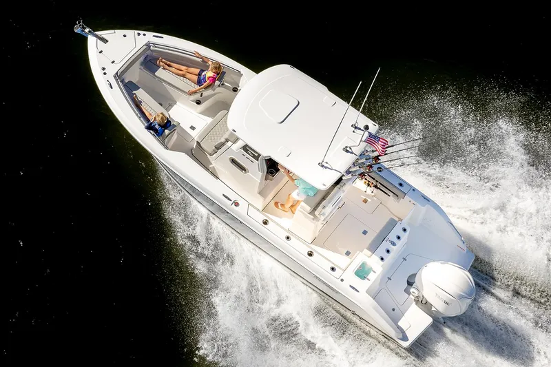 Slide: The Image of Manufacturer Provided Image: 2025 Pursuit S 248 Sport boat cruising with passengers on deck, aerial view. - 4