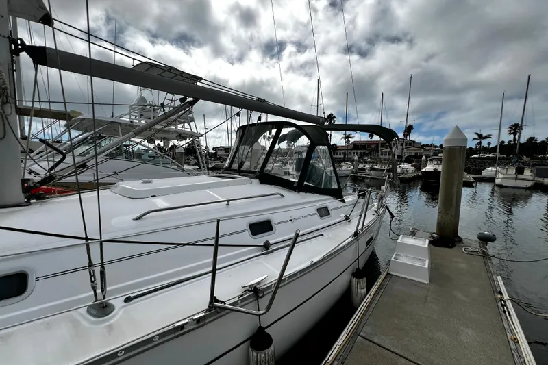 Slide: The Image of 2002 Beneteau 331 sailboat docked at marina under cloudy sky. - 13