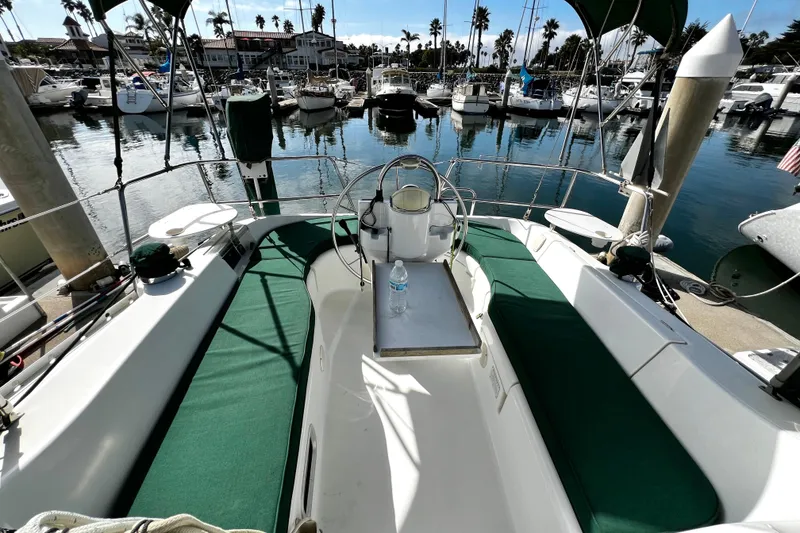 Slide: The Image of 2002 Beneteau 331 sailboat cockpit with green seating, docked in a marina. - 21