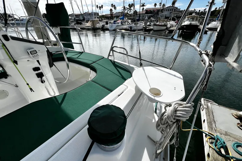 Slide: The Image of 2002 Beneteau 331 sailboat cockpit with green cushions, docked in a marina. - 27