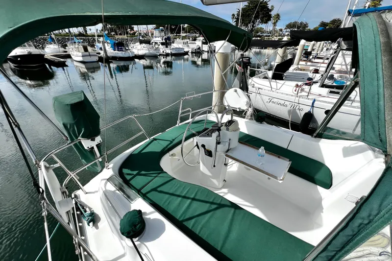 Slide: The Image of 2002 Beneteau 331 sailboat with green canopy docked in a marina. - 29