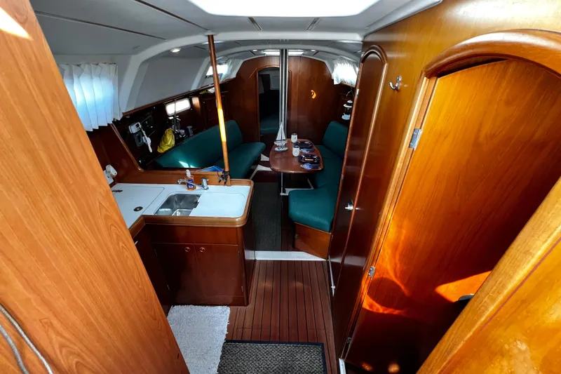 Slide: The Image of Interior of 2002 Beneteau 331 sailboat with wood finish and green seating. - 32