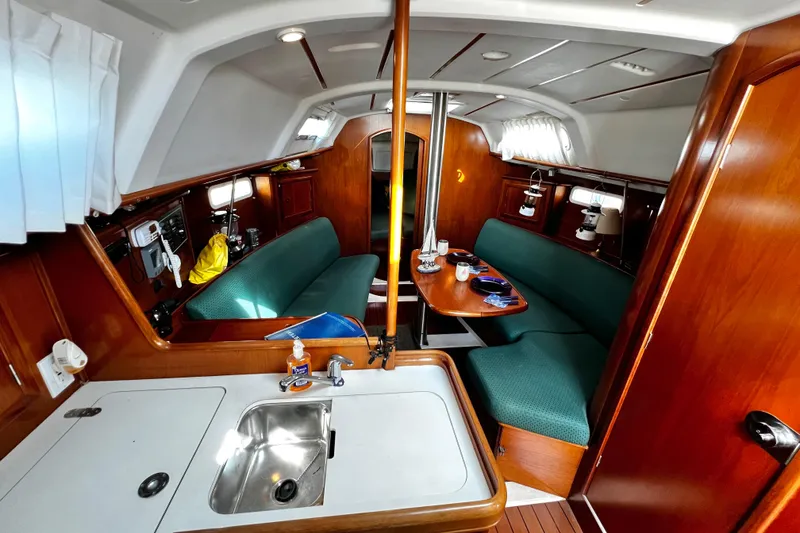 Slide: The Image of Interior of 2002 Beneteau 331 sailboat with wood finish and green seating. - 33