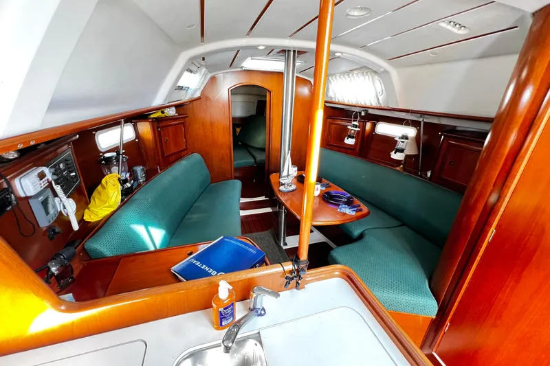 Slide: The Image of Interior of 2002 Beneteau 331 sailboat with wood finish and green seating. - 38