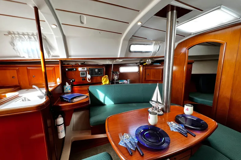 Slide: The Image of Interior of 2002 Beneteau 331 sailboat with dining area and wooden cabinetry. - 44