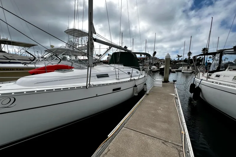 Slide: The Image of 2002 Beneteau 331 sailboat docked at marina under cloudy sky. - 6