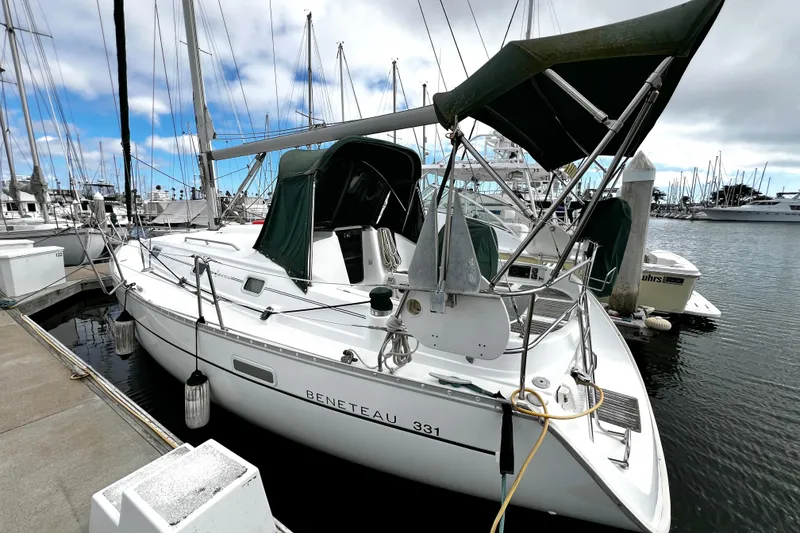 Slide: The Image of 2002 Beneteau 331 sailboat docked at marina under cloudy sky. - 7