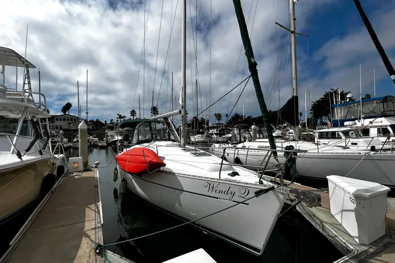 Slide: The Image of 2002 Beneteau 331 sailboat docked in marina, featuring a red kayak on deck. - 9
