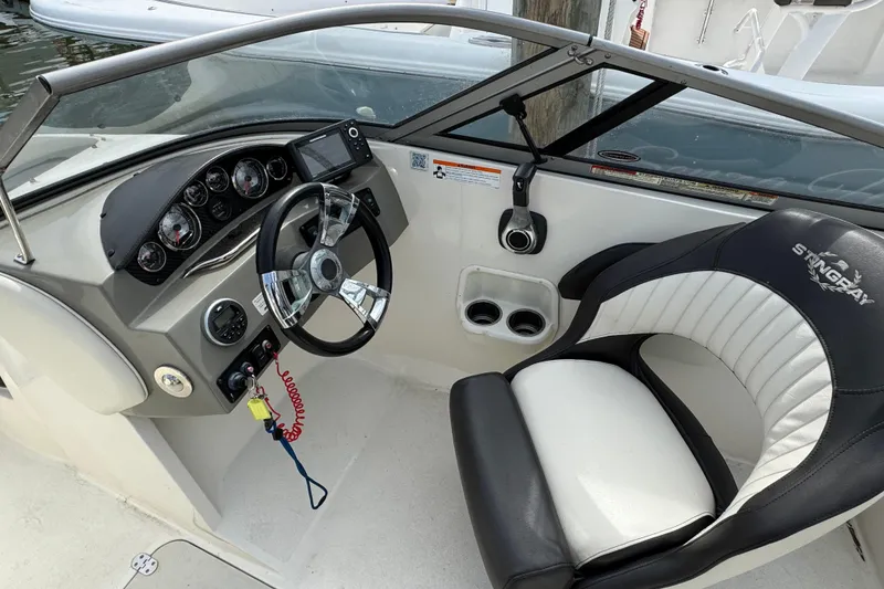 Slide: The Image of 2018 Stingray 204 LR boat cockpit with steering wheel and comfortable seating. - 13