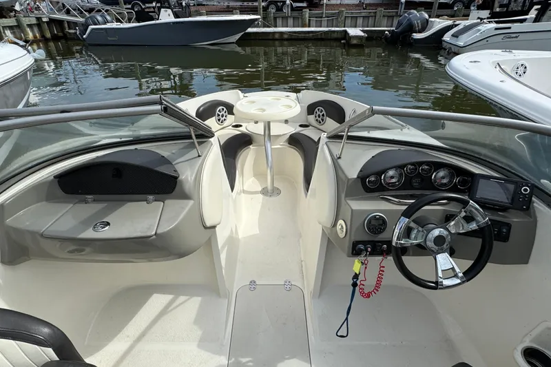 Slide: The Image of 2018 Stingray 204 LR boat interior with steering wheel, dashboard, and seating area. - 14