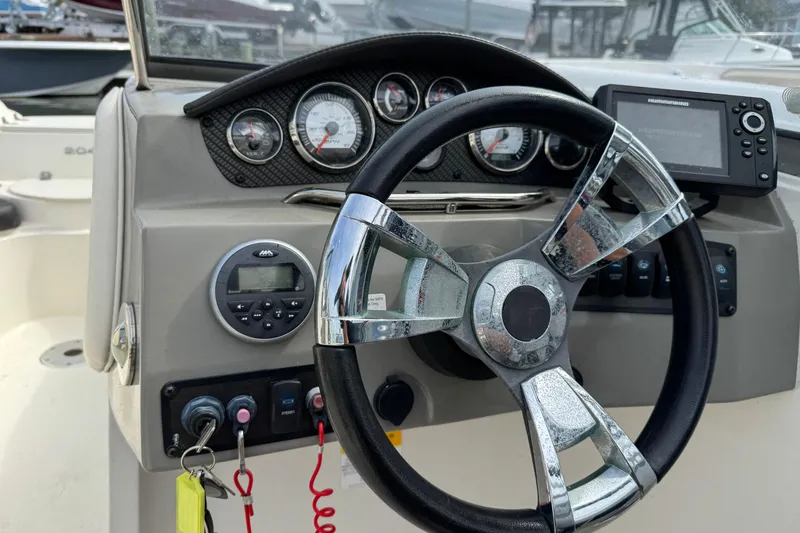 Slide: The Image of Steering wheel and dashboard of 2018 Stingray 204 LR boat with gauges and controls. - 4