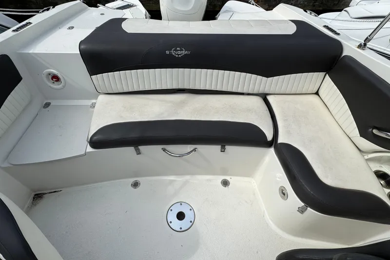 Slide: The Image of 2018 Stingray 204 LR boat interior with black and white seating arrangement. - 6