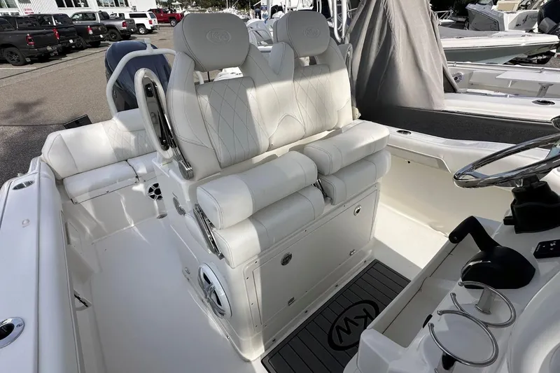 Slide: The Image of 2026 Key West 239 FSR boat interior with white seating and steering wheel. - 14