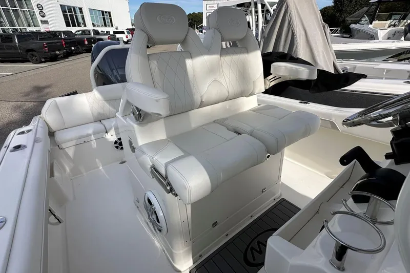Slide: The Image of 2026 Key West 239 FSR boat interior with white seating and steering wheel. - 15