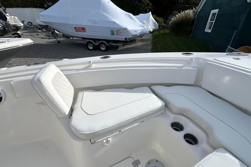 Slide: The Image of 2026 Key West 239 FSR boat interior with white seating and cup holders. - 26