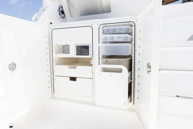 Slide: The Image of Manufacturer Provided Image: 2025 Pursuit OS 405 Offshore boat storage compartment with organized shelves and drawers. - 15