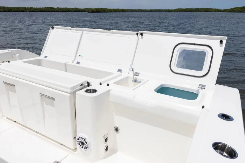Slide: The Image of Manufacturer Provided Image: 2025 Pursuit OS 405 Offshore boat deck with storage compartments, on a serene water backdrop. - 16