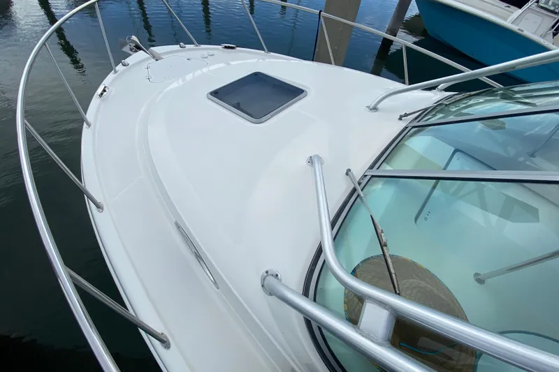 Slide: The Image of 2007 Robalo R305 Walkaround boat docked at marina, featuring spacious deck and twin engines. - 12