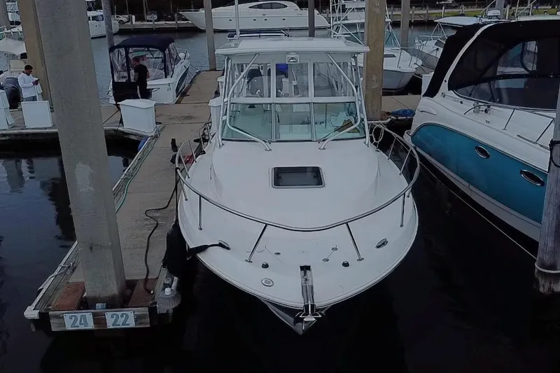 Slide: The Image of 2007 Robalo R305 Walkaround boat on trailer, parked outdoors under a cloudy sky. - 2