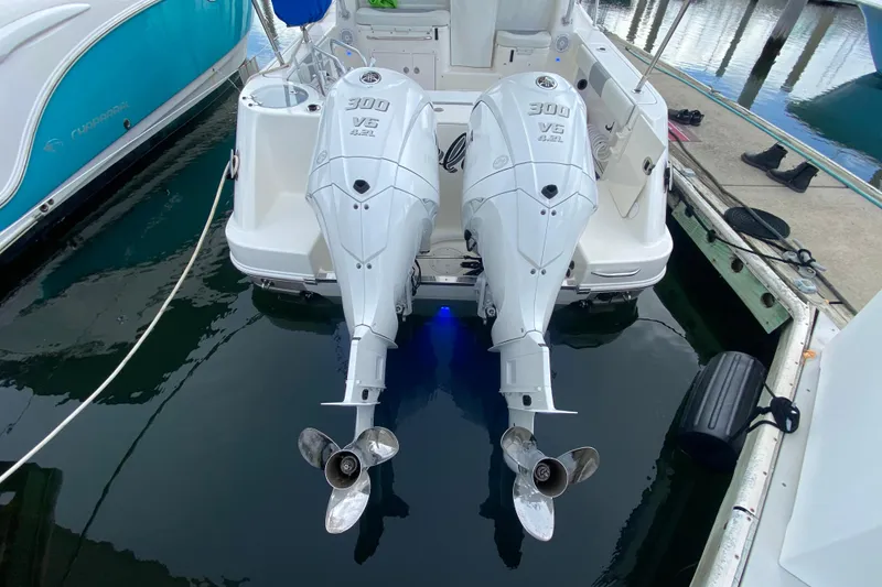 Slide: The Image of 2007 Robalo R305 Walkaround with dual outboard engines docked at marina. - 35