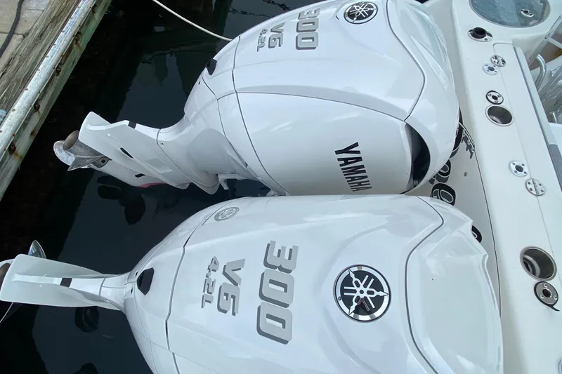 Slide: The Image of 2007 Robalo R305 Walkaround boat with dual outboard engines docked at marina. - 36