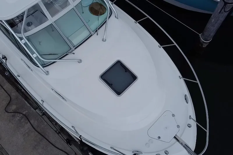 Slide: The Image of 2007 Robalo R305 Walkaround boat docked at marina, featuring sleek design and spacious deck. - 4