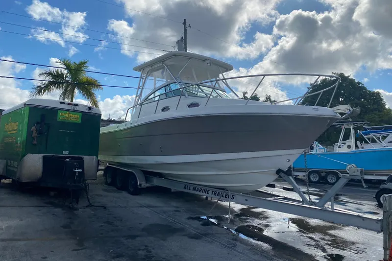 Slide: The Image of 2007 Robalo R305 Walkaround boat docked at marina with palm trees in background. - 50