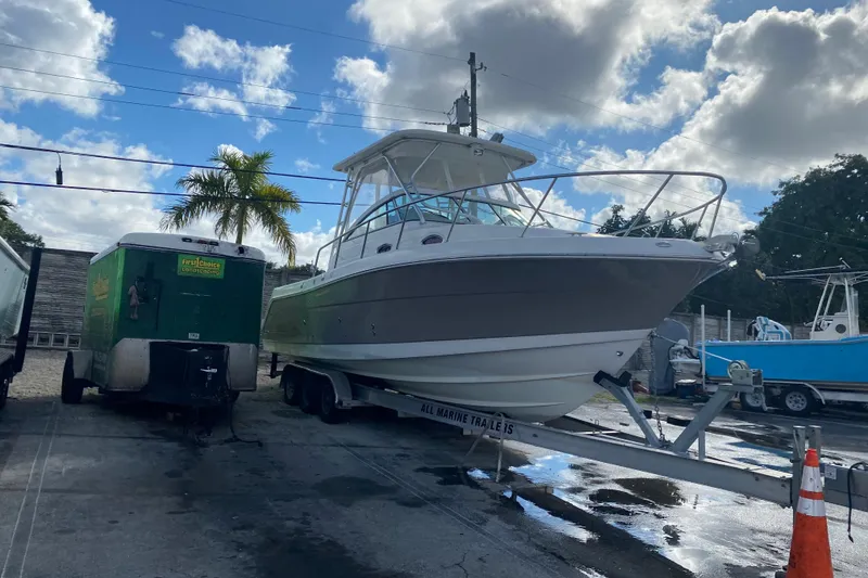 Slide: The Image of 2007 Robalo R305 Walkaround boat on trailer, parked outdoors under cloudy sky. - 51