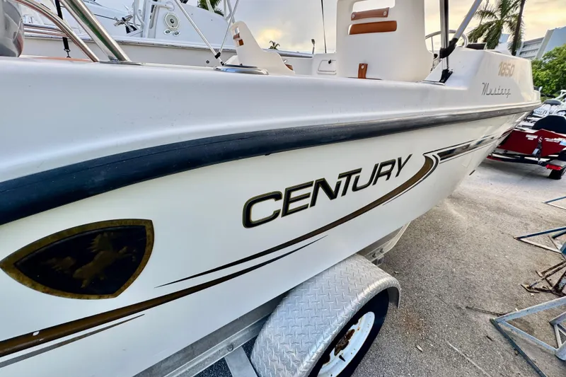 Slide: The Image of 2006 Century 1850 Mustang boat interior with brown seats and outboard motor. - 19