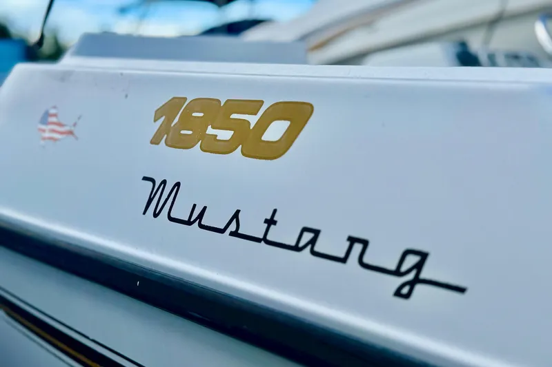 Slide: The Image of 2006 Century 1850 Mustang boat interior with white seating and brown cushions. - 20