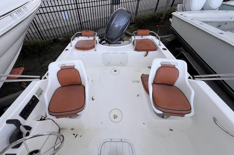 Slide: The Image of Century 1850 Mustang 2006 boat interior with brown cushioned seats and outboard motor. - 4