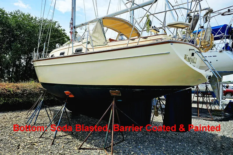 The Image of 2000 Island Packet 350 sailboat, soda blasted, barrier coated, and painted, on stands outdoors. - 0