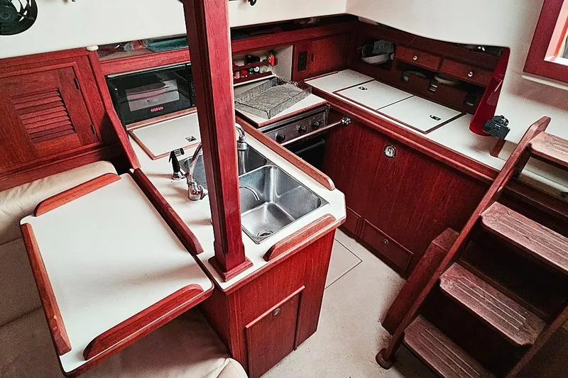 Slide: The Image of Interior of 2000 Island Packet 350 sailboat kitchen with wood cabinetry and stainless steel sink. - 10