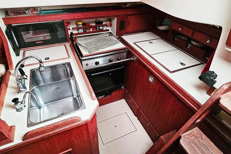 Slide: The Image of Galley kitchen in 2000 Island Packet 350 sailboat with sink, stove, and microwave. - 11