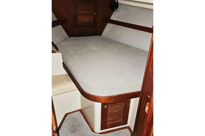 Slide: The Image of Cozy cabin interior of 2000 Island Packet 350 sailboat with wooden accents and cushioned berth. - 12