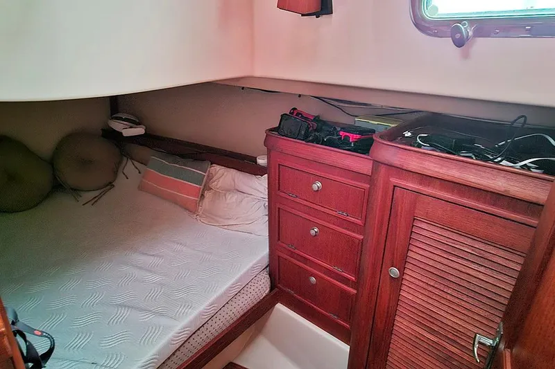 Slide: The Image of Cozy cabin interior of 2000 Island Packet 350 sailboat with wooden cabinetry and bed. - 14