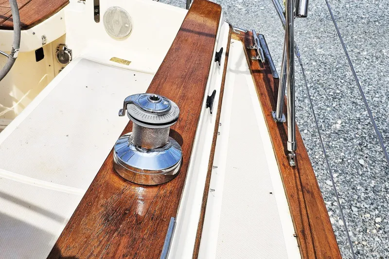 Slide: The Image of Island Packet 350 sailboat deck with winch, showcasing teak wood finish, 2000 model. - 16