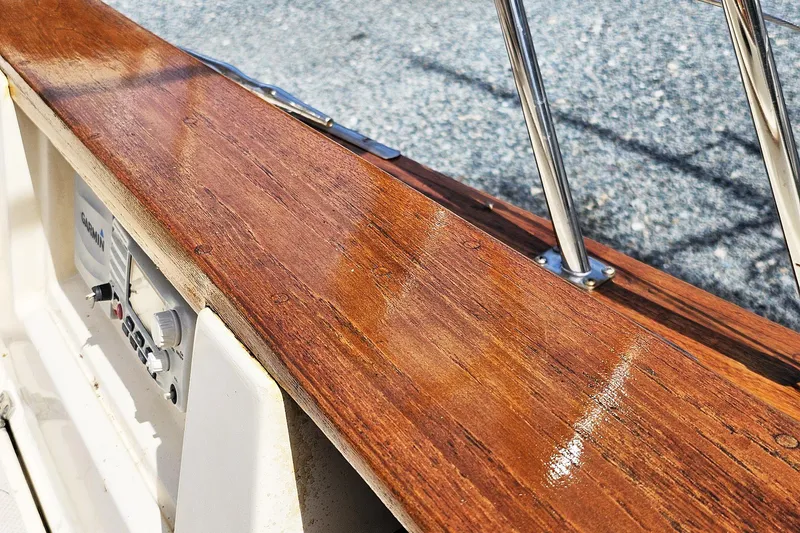 Slide: The Image of Polished wooden deck of 2000 Island Packet 350 sailboat with metal railing. - 17