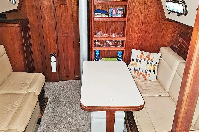 Slide: The Image of Interior of 2000 Island Packet 350 sailboat with cozy seating and wooden cabinetry. - 4