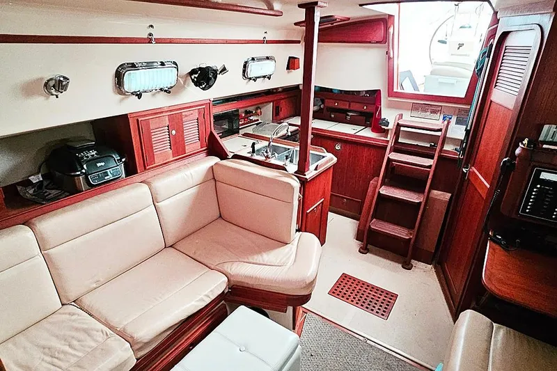 Slide: The Image of Interior of 2000 Island Packet 350 sailboat with cozy seating and wooden cabinetry. - 7