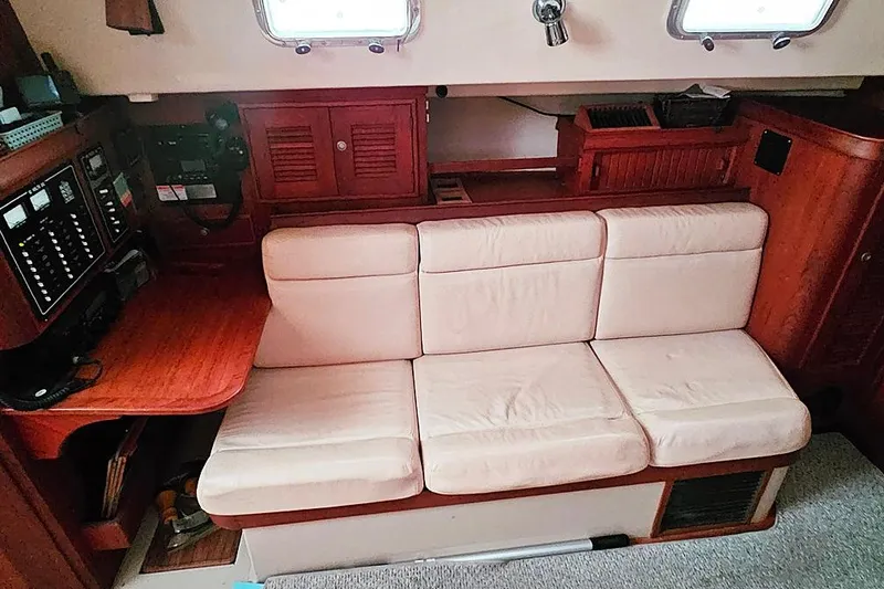 Slide: The Image of Interior of 2000 Island Packet 350 sailboat with beige sofa and wooden cabinetry. - 9
